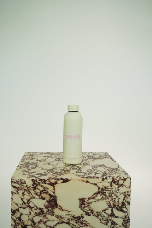 The Remi Bottle in cream on marble plinth