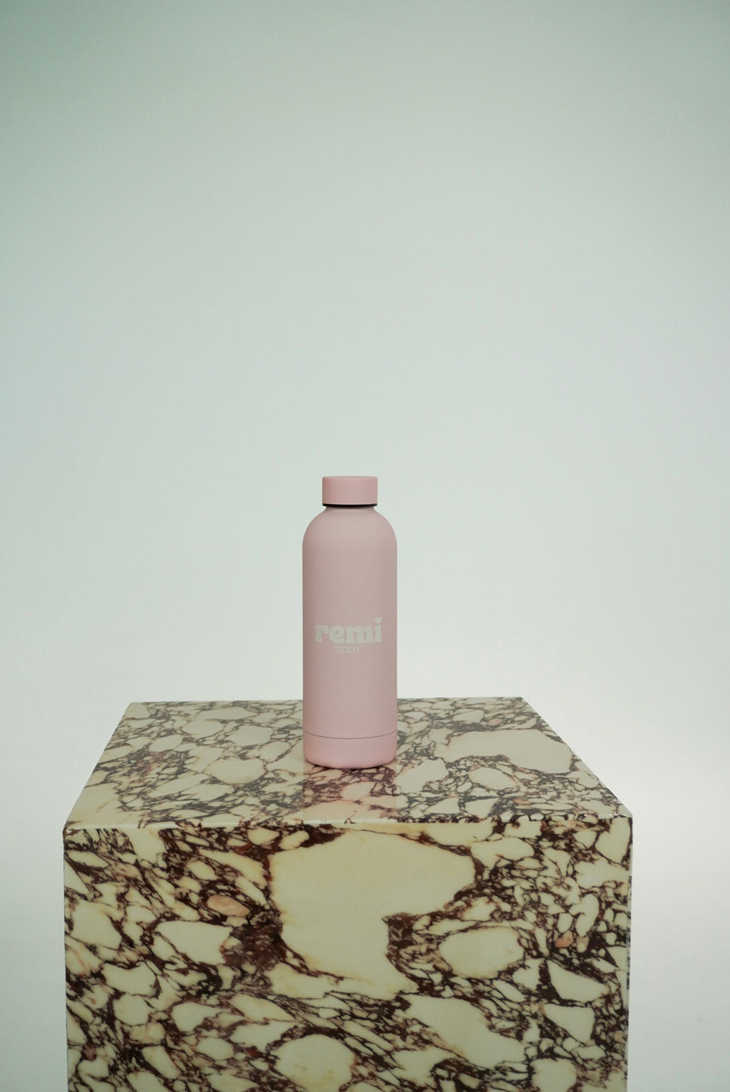 The Remi Bottle in blush pink on marble plinth