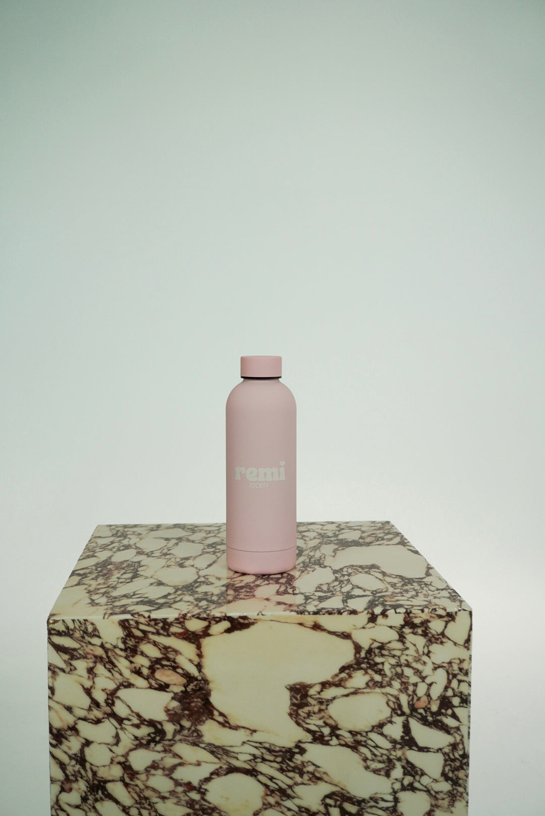The Remi Bottle in blush pink on marble plinth